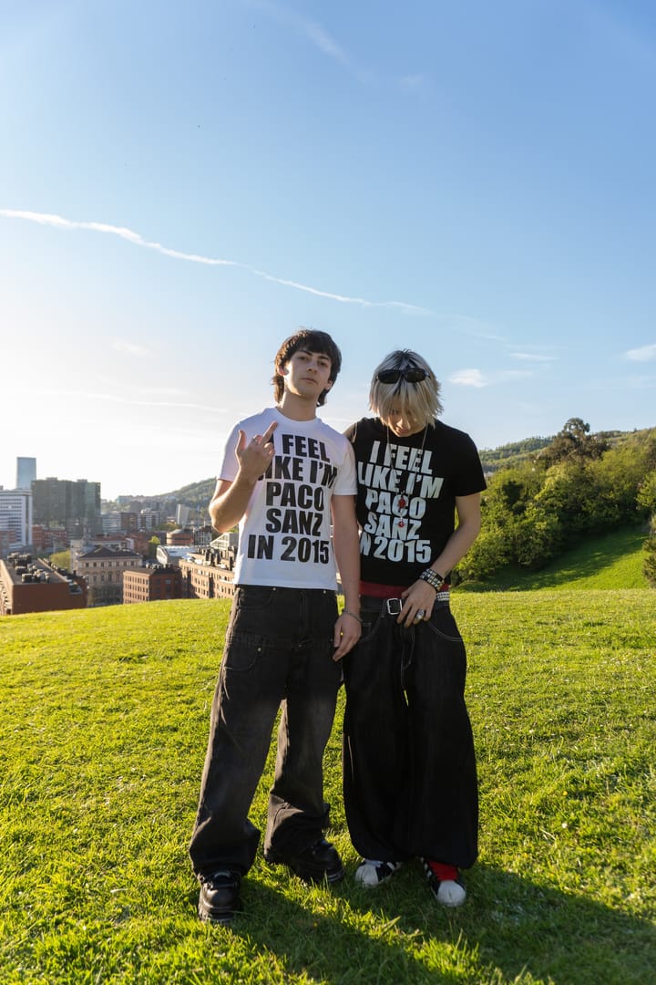 Dos chicos de frente con las camisetas blanca y negra I feel like I’m Paco Sanz in 2015 en un parque de Bilbao, uno haciendo los cuernos